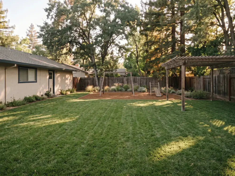 Illustrative concept image, not a customer project: the same backyard as an open lawn play area with a simple wooden swing set.